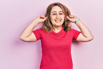 Middle age caucasian woman wearing casual clothes smiling pulling ears with fingers, funny gesture. audition problem