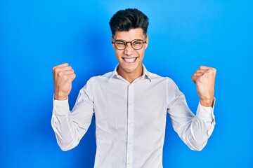 Young hispanic man wearing casual clothes and glasses screaming proud, celebrating victory and...