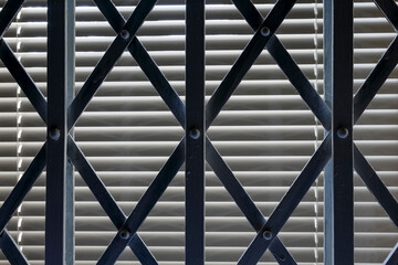 Folding steel grille is visible in front of a closed window