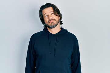 Middle age caucasian man wearing casual sweatshirt relaxed with serious expression on face. simple and natural looking at the camera.
