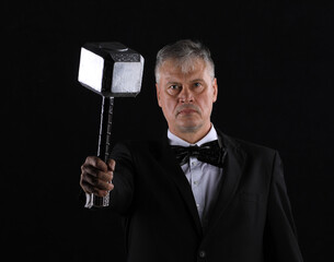 businessman with viking hammer on black background