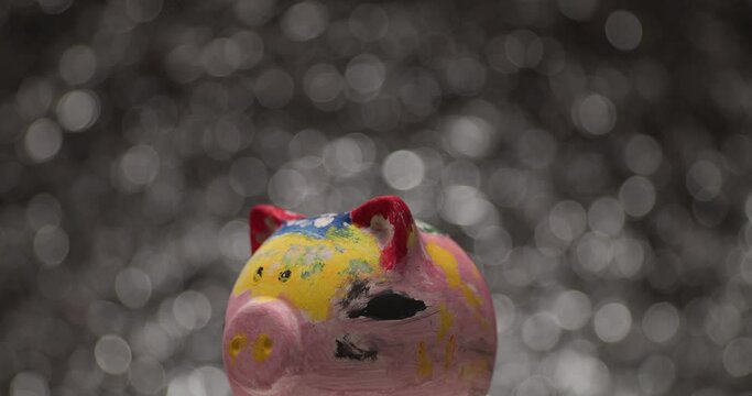 artistic piggy bank turning around, bubbles falling all over and popping in it's head