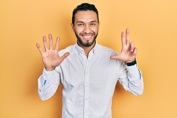 Hispanic man with beard wearing business shirt showing and pointing up with fingers number eight while smiling confident and happy.