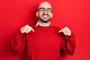 Young bald man wearing casual clothes and glasses looking confident with smile on face, pointing oneself with fingers proud and happy.