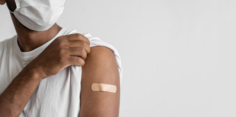 Man  showing his arm with bandage after receiving covid vaccination, young men received a corona vaccine panoramic banner