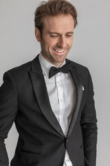 businessman looking down, smiling and holding his hands in pockets