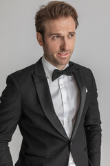 attractive businessman holding his hands in pockets and looking away