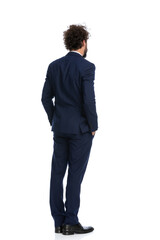 businessman looking away and holding his hands in his pockets