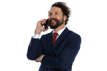 handsome businessman talking on the phone while crossing his arms