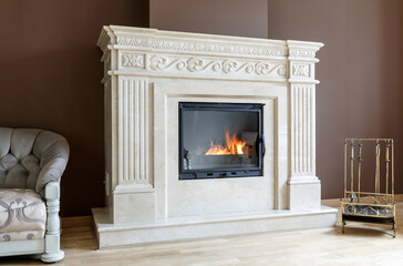 White marble fireplace in classic style with burning wood inside. - 455114660