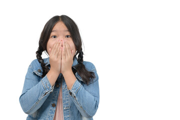 Surprised little girl wearing denim jacket covering her mouth and looking at camera