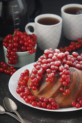 A cake with fresh red currant and tea