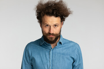 Fototapeta na wymiar portrait of casual unshaved man with curly hair and beard posing