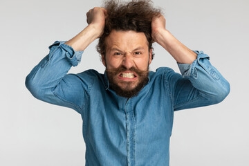 angry bearded man being nervous and pulling hair out