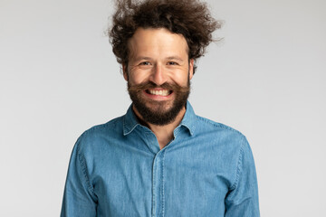 happy young man with moustache and beard being excited and smiling