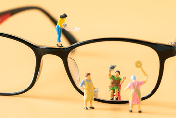 Miniature people Housewife Maid or Worker standing and cleaning dirty reading glasses using as Hospitality Hotel cleaning service business or health care healthy and wellness life style safety concept