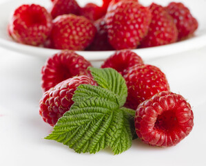 image of raspberries with leaves on a white background