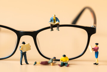 Miniature people figures Businessman sitting and reading Financial book or newspaper on optical glasses with copy space using as Success Business development and Blockchain Commerce Strategy Planning