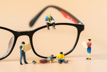 Miniature people figures Businessman sitting and reading Financial book or newspaper on optical glasses with copy space using as Success Business development and Blockchain Commerce Strategy Planning