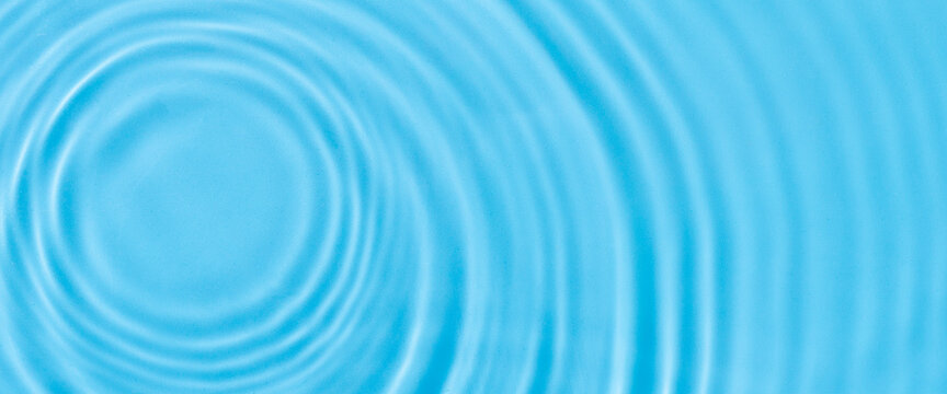 Wave From A Drop Of Water On Blue Water Under Natural Light. Top View, Flat Lay. 