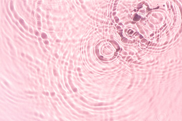 Texture of drops on pink water under sunlight. Top view, flat lay