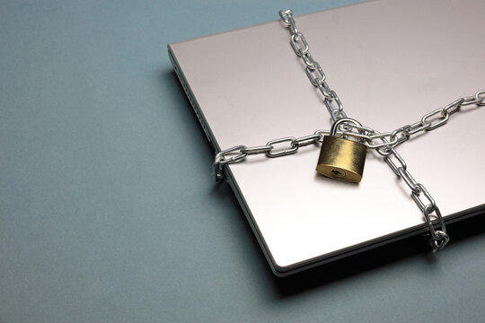 laptop with chain and padlock - Powered by Adobe