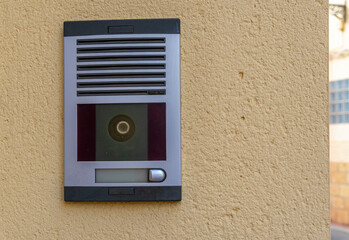 Electronic doorbell with camera on the entrance wall of a house. 