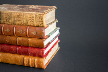 Naklejka premium Stack of old books on dark background