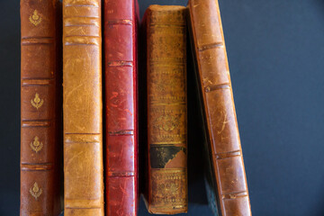 Row of old books on dark background