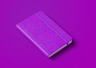 Purple closed notebook isolated on color background