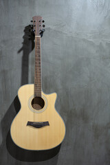 Fototapeta na wymiar Acoustic guitar hanging on a concrete wall