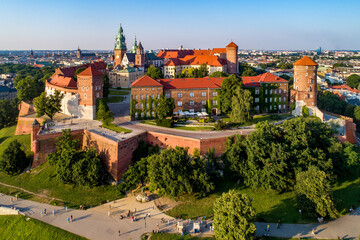 Krakow, Poland. Historic royal Wawel castle and cathedral. Aerial view at sunset in summer. Old town with St. Mary church in the background. Park, promenades and walking people