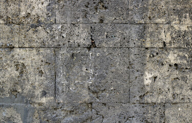 Granite stone surface of a wall with big bricks, textured with moisture - dirty pattern with squares for a background	