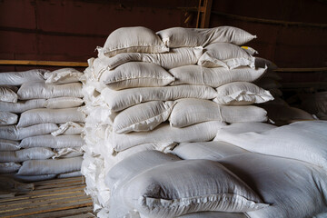 Large cloth bags with unknown bulk contents are lying in the warehouse. An image illustrating the...