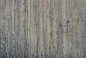 Old gray wall of cement with thin grooves and lines of moisture - dirty and creepy pattern for a background texture