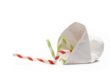 Disposable crumpled, paper cup and drinking straw for throwing away and recycling isolated on white...