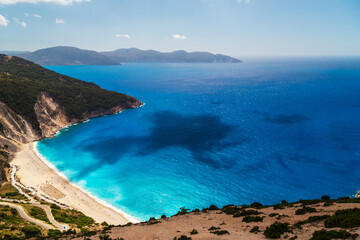 A top view at Myrtos Beach and fantastic turquoise and blue Ionian Sea water. Aerial view, summer scenery of famous and extremely popular travel destination in Cephalonia, Greece, Europe