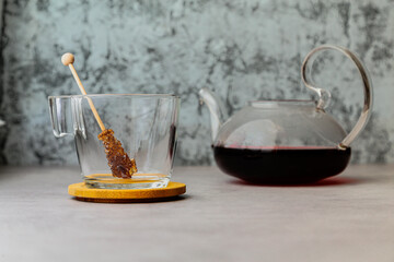 a sugar lollipop inside mug next to a teapot with karkade