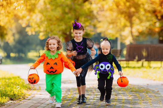 Happy Halloween. Three Running Kids With A Basket For Sweets