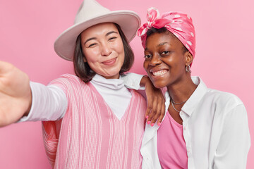 Mixed race girlfriends pose for making selfie enjoy leisure time take picture together being in...