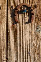 Horseshoe and evil eye bead on old wooden door