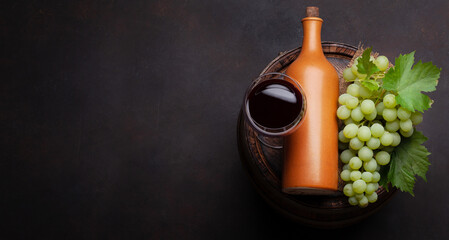 Obraz premium Wine bottle and glass on old barrel