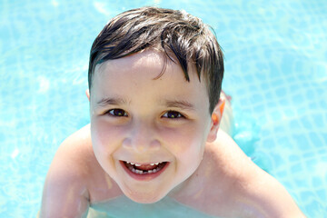 retrato de un niño feliz en una piscina - obrazy, fototapety, plakaty