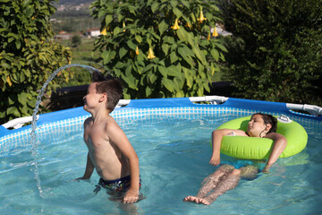 niño con el pelo largo salpicando en la piscina