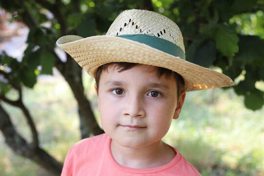 ni&ntilde;o con gorro de paja feliz en la naturaleza