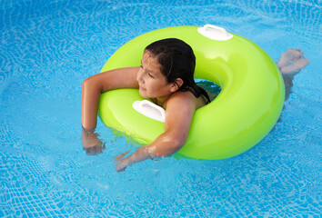 niño en la piscina con un flotador