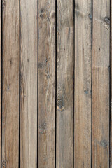 The texture of a wooden fence made of unpainted weathered wood. A high resolution. Vertical image.