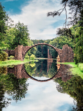 Rakotz Bridge, Rakotzbrucke in Kromlau, Saxony, Germany. Fantastic landscape in Azalea and Rhododendron Park Kromlau. Reflection of bridge in water of Rakotzsee. traveling and travel goals for tourism