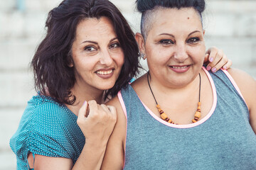 Two adult twin sisters hugging. Different styles