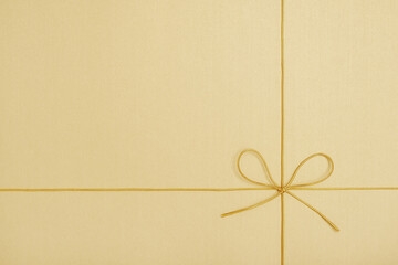 Shiny golden string tied in a bow on yellow background